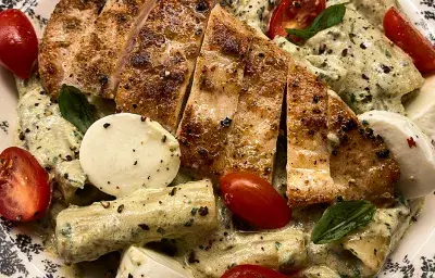 Pasta al pesto cremoso con pollo y ensalada caprese